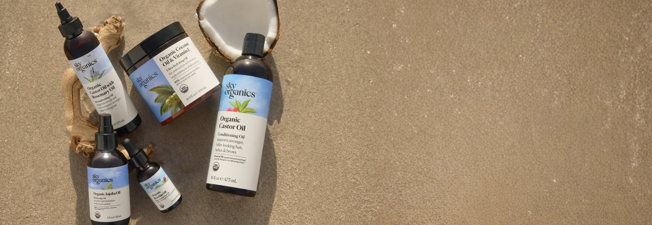 Sky Organics body and hair oils photographed on sand