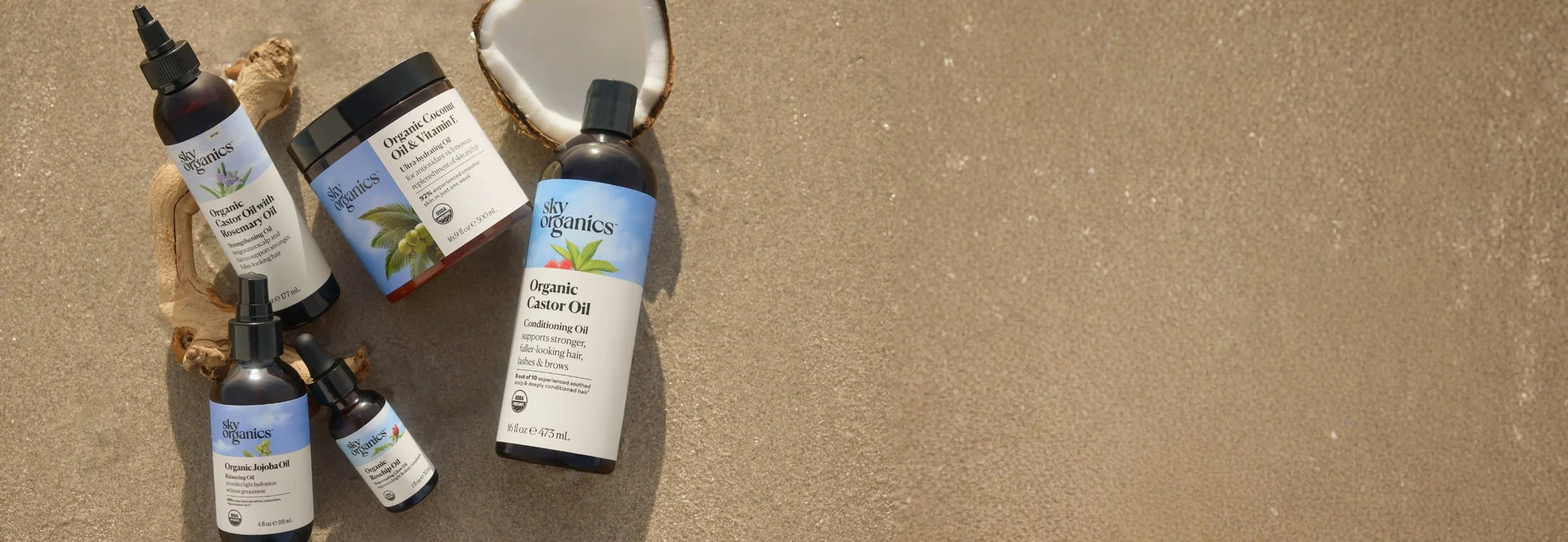 Sky Organics body and hair oils photographed on sand