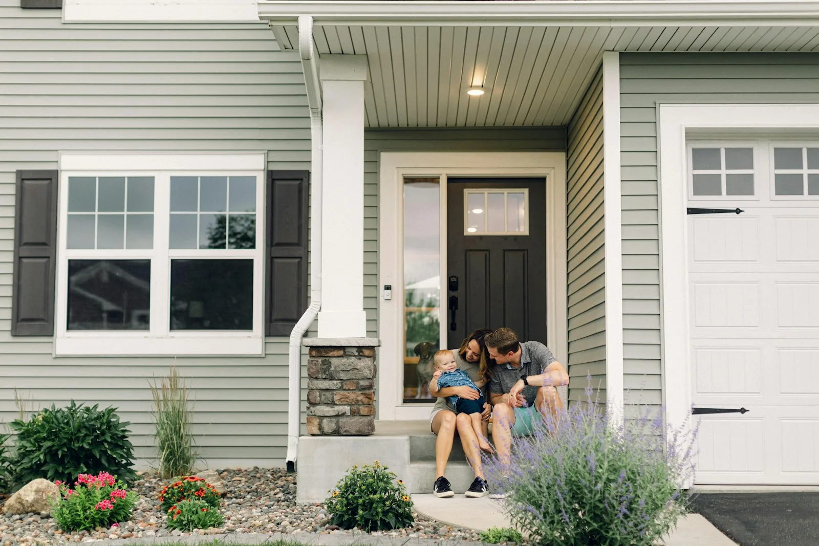 Children on the front steps of a suburban house
