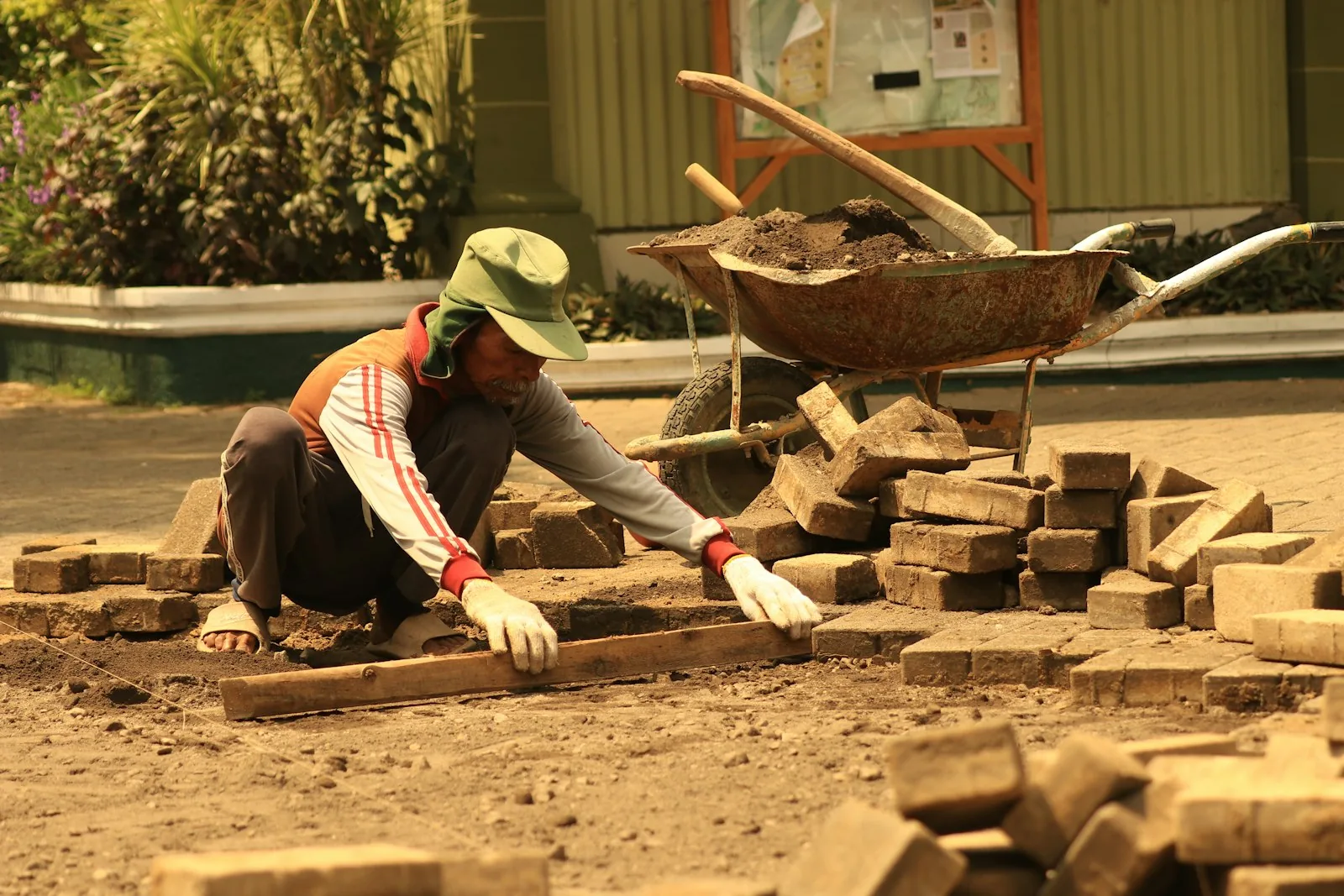 A mason setting pavers on a walkway