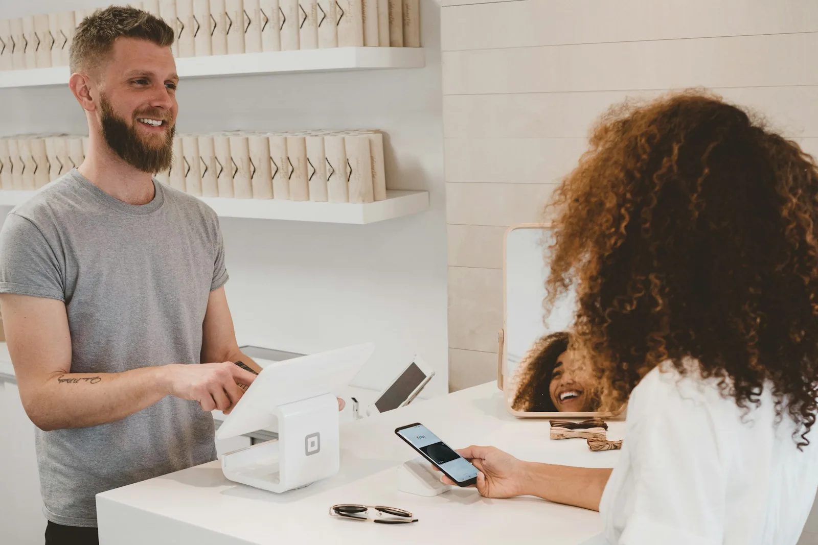 A shop owner and a customer at a checkout counter