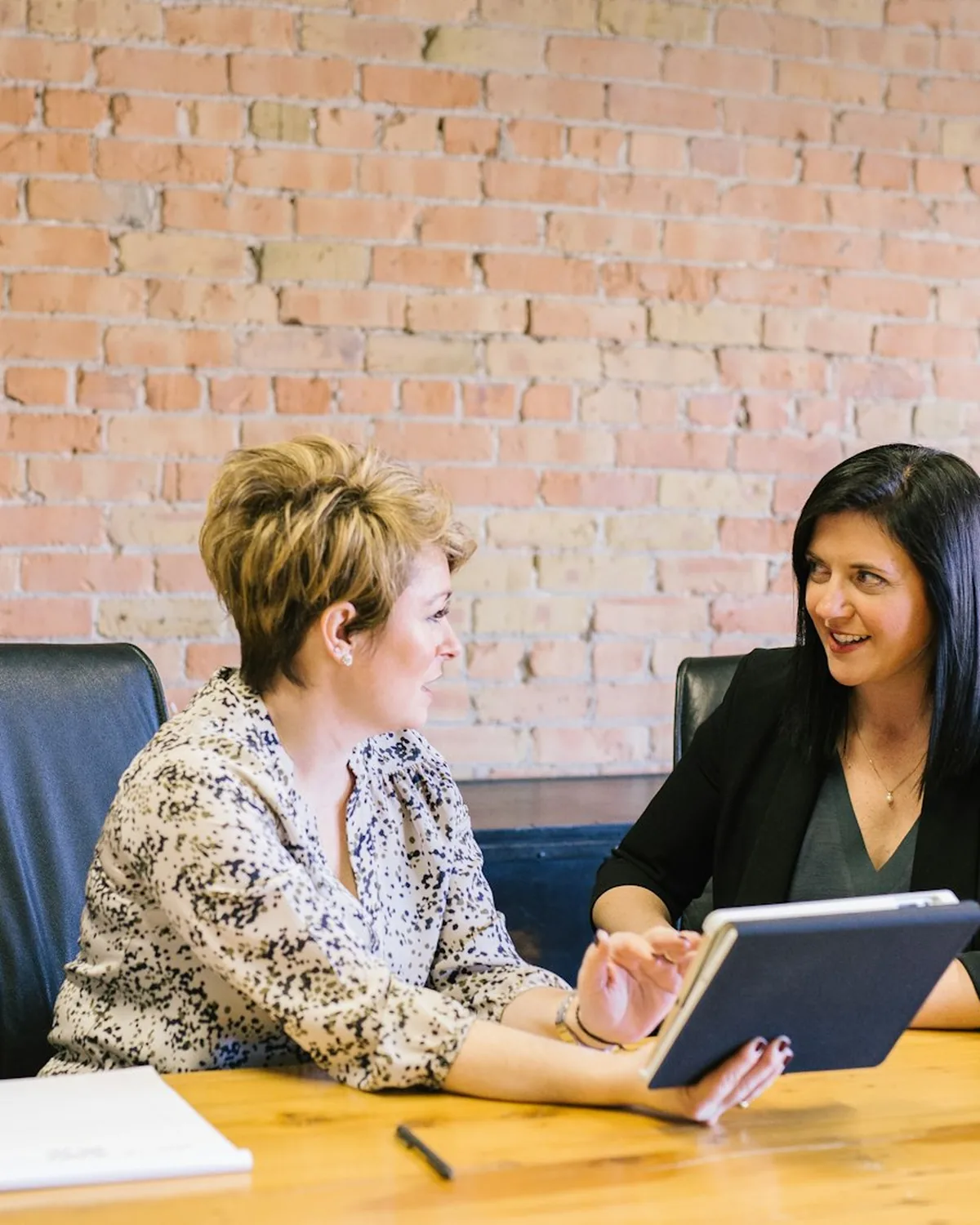 Two people reviewing work together at a desk